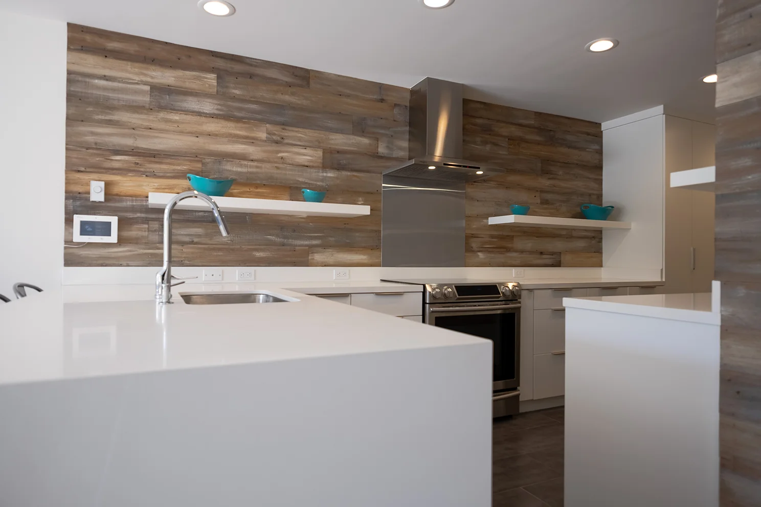 New kitchen featuring breakfast bar with quartz waterfall counter and recycled redwood full height backsplash creates a contemporary rustic feel.