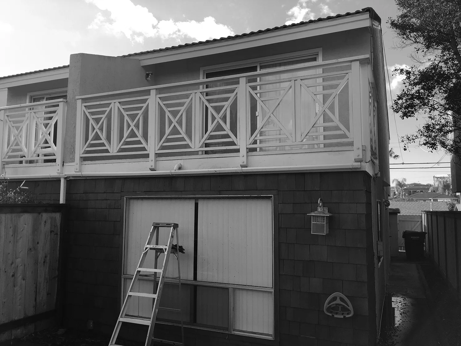 Existing street facade with picture window limiting access to front yard and dated lighting fixtures.